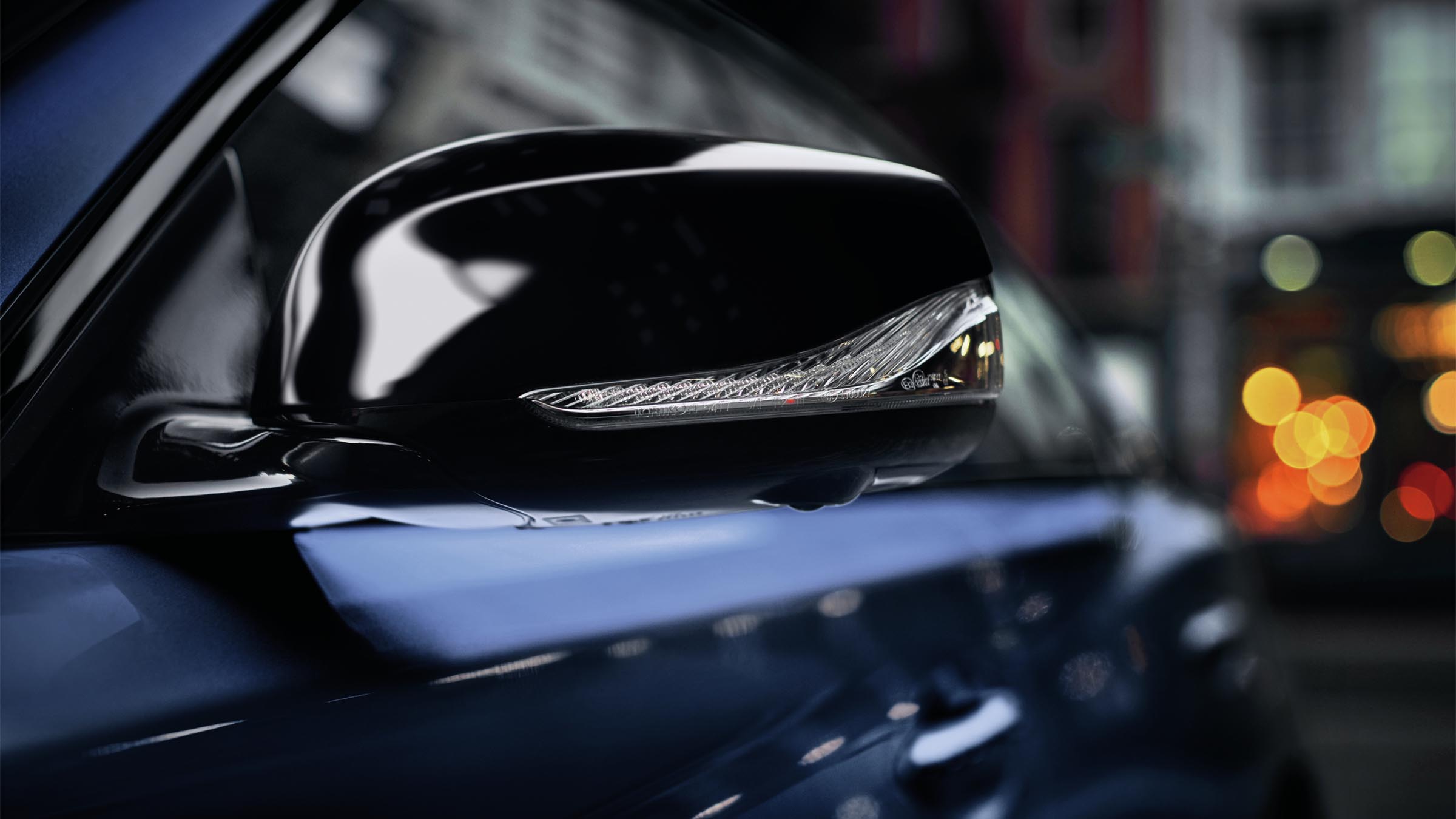 A close-up of a blue 2022 INFINITI Q50 sedan side mirror.